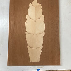 Marquetry feather/leaf inlaid into a darker ground