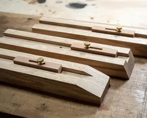 Several wooden jigs used to cut the angles needed for kumiko frames