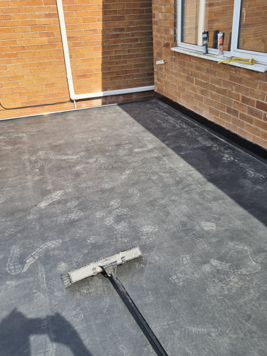 Roof being worked on with a brush on a sunny day.