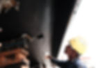 Ratanachai Shipyard's painter using roller brush to apply antifouling paint to a superyact's hull