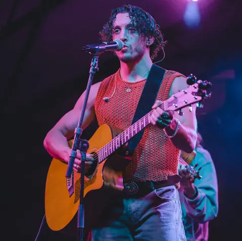 Musician performing with an acoustic guitar at SXSW.