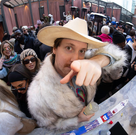 Man in a cowboy hat and fur coat at an Aspen apres-ski.