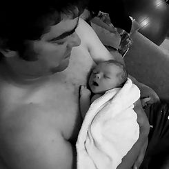 New dad with second baby after poweful birth at home. Birth partner. Freebirthed baby.