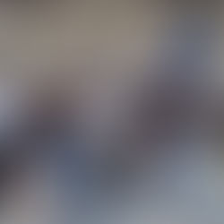 Group of people in matching "LEAP" shirts and pilot uniforms pose in front of an airplane inside a hangar. Bright and casual atmosphere.