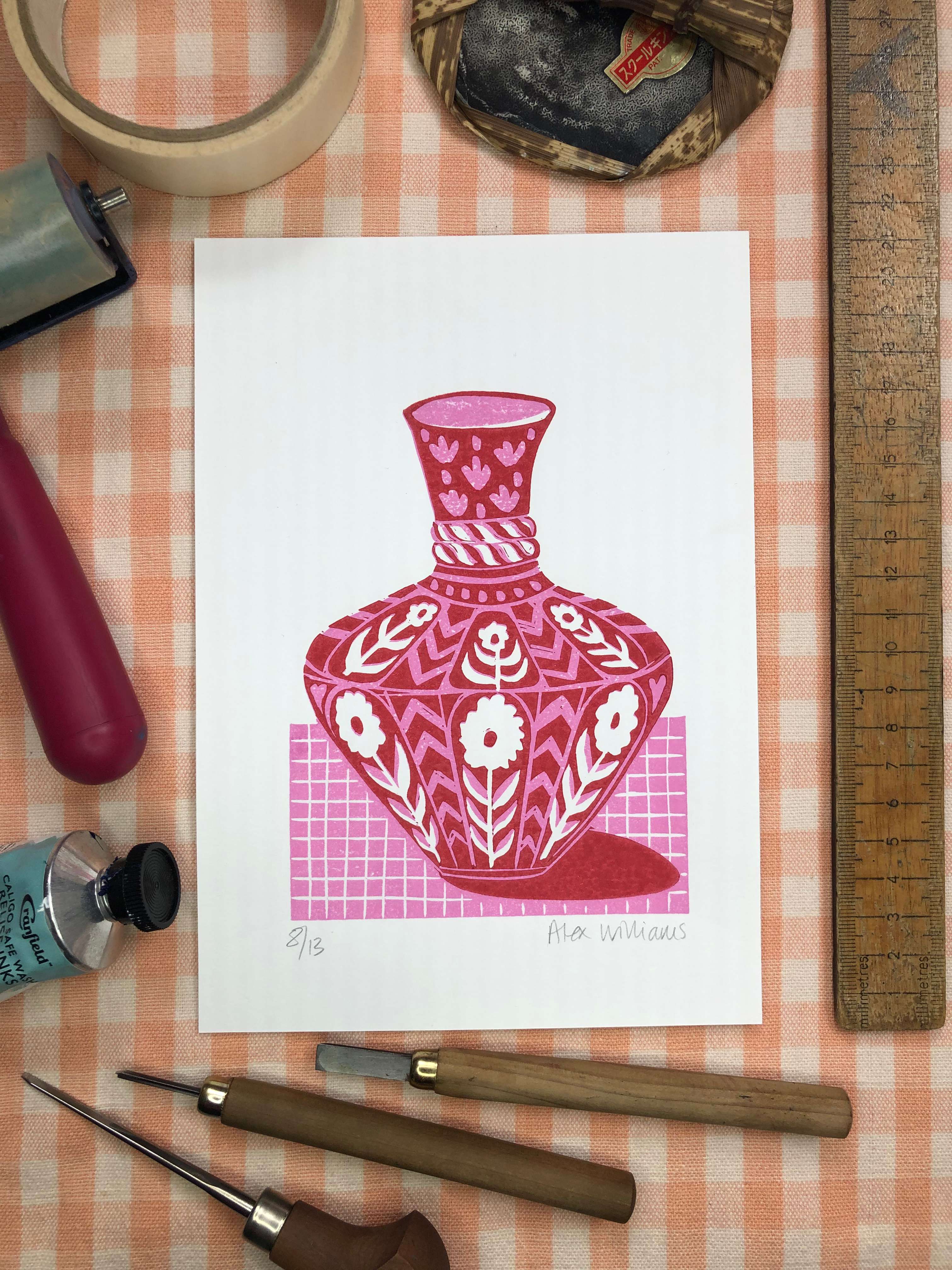 Original reduction linocut print of a pink and red vase with flowers on a pink lined surface
