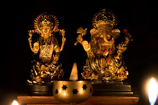 God Laxmi Ganesh statue Diwali Festival with candle burning on black background.jpg