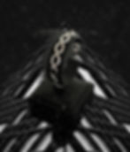 Bracelet doré sur présentoir noir avec fond architectural. Modèle: Infinity Steel.