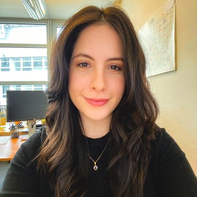 Portrait of Laura Grisi smiling in an office, wearing a black top