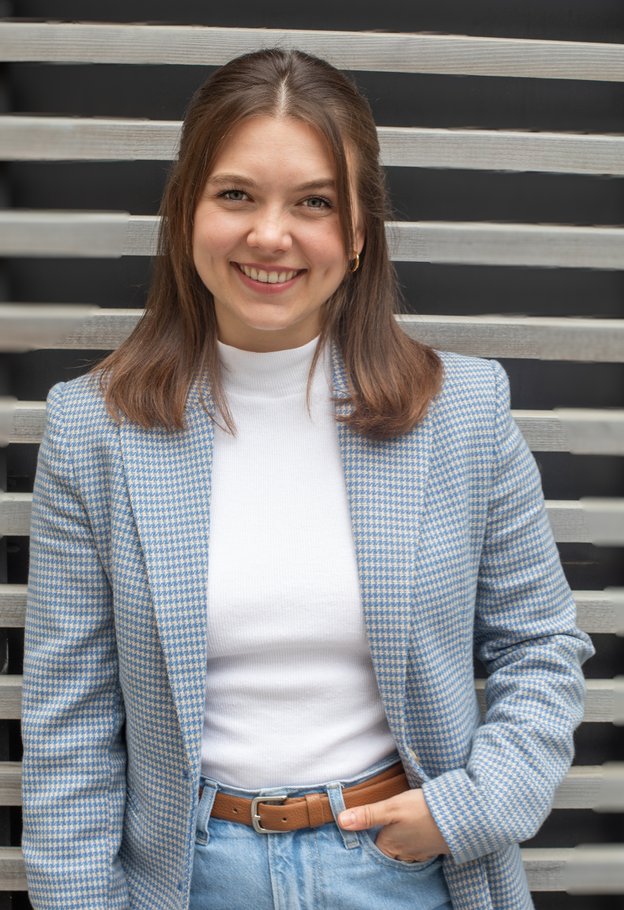 Portrait of Anna Krispin smiling, wearing a light checked blazer
