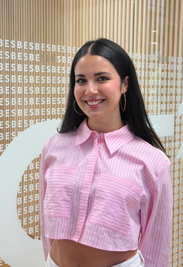 Portrait of Yosune Uribe smiling, wearing a pink striped shirt