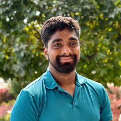 Portrait of Nikhilesh Acharya outdoors, wearing a teal polo shirt