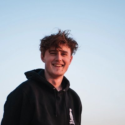 Portrait of Philipp smiling outdoors against a clear sky, wearing a black hoodie