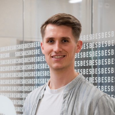Portrait of Moritz Wigger smiling, wearing a light grey shirt