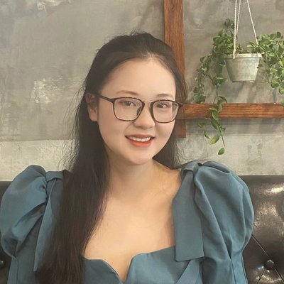 Portrait of Chau Giang Nguyen smiling, wearing glasses and a blue-green top