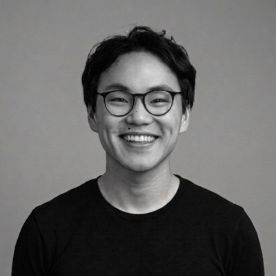 Black-and-white portrait of Hoang Nguyen smiling, wearing round glasses