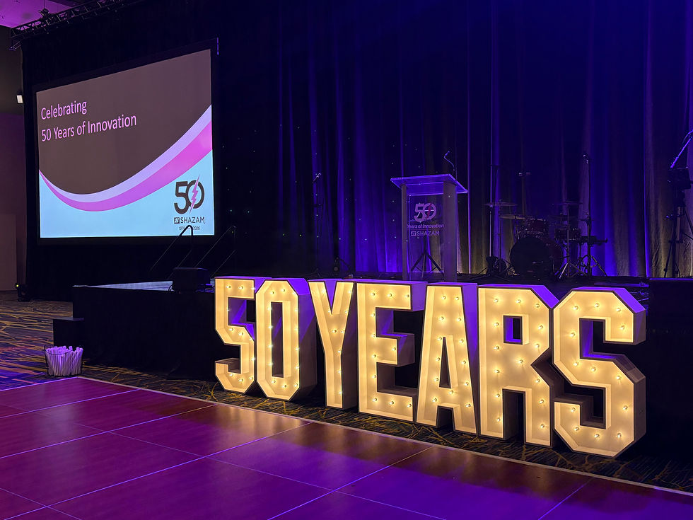 Warm illuminated marquee letters against a dark event backdrop for company anniversary celebration