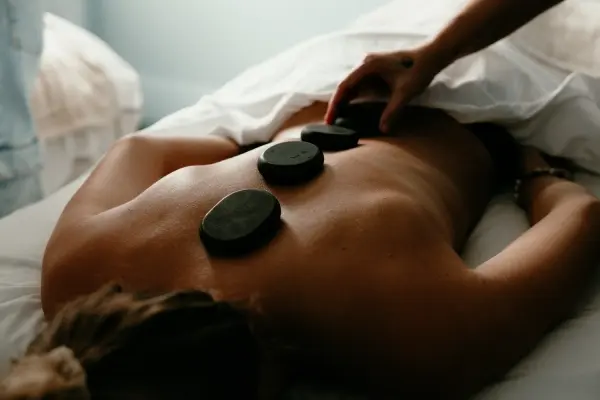 hot stones are placed on a patient's back during a hot stone massage