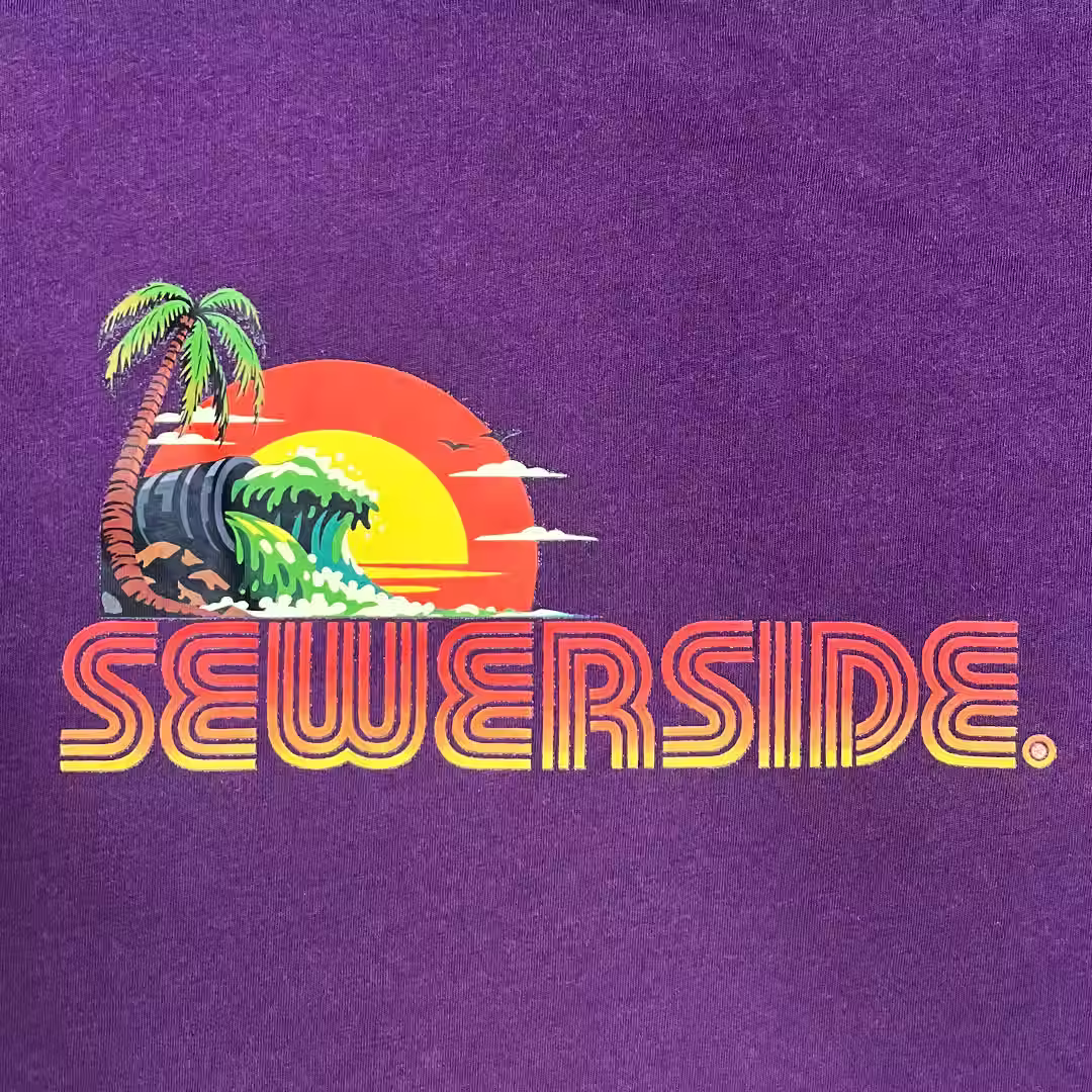 PIPE ISLAND with gradient orange text on small purple tee