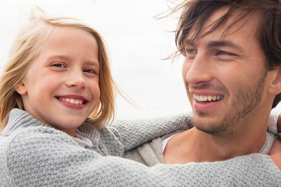 father holding daughter and smiling