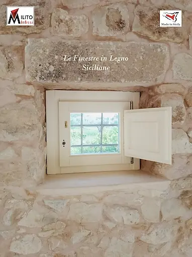 Custom white wooden window featuring classic internal shutters (scuretti) for a historic property restoration in Sicily.