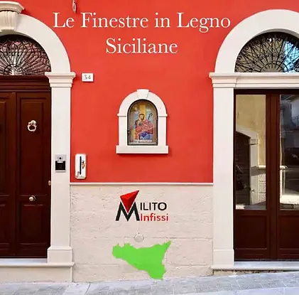 Facciata tradizionale in Sicilia con portone d'ingresso in legno massello a doppia anta ad arco e finestra coordinata. Design classico con battenti ad anello, ideale per abitazioni nei centri storici. Realizzazione artigianale Milito Infissi.