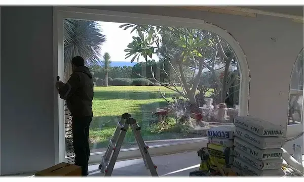 vetrata in legno laccato ad arco durante la posa in opera