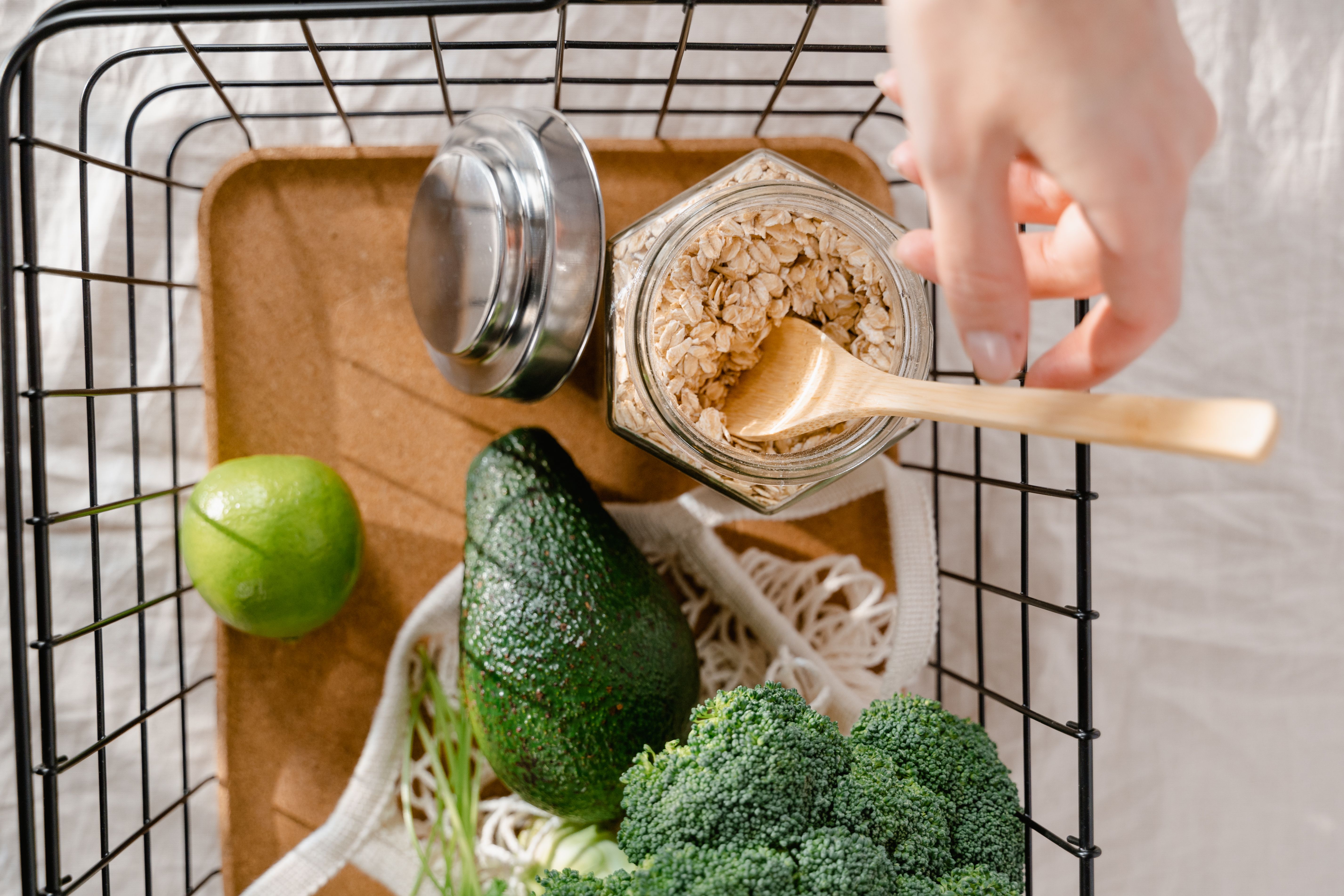 A calm kitchen basket with oats, avocado, broccoli, and produce representing practical food-based glyphosate exposure reduction.