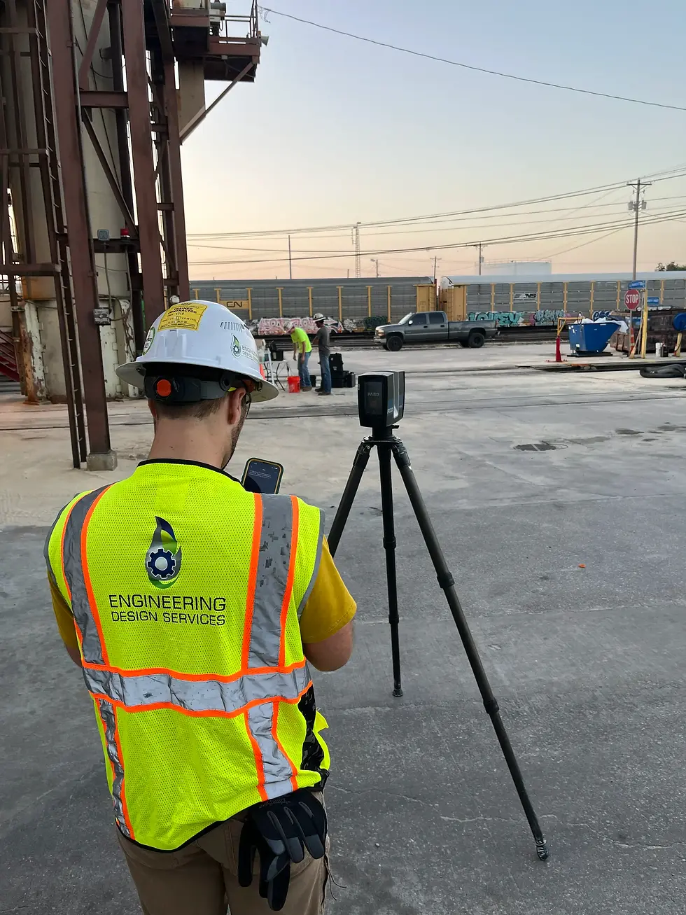 engineer using tripod mounted scanning equipment to perform field data collection and inspection at sand silo industrial site