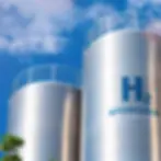 large industrial hydrogen storage tanks with H2 labeling stainless steel construction safety railings and blue sky background at an energy production facility