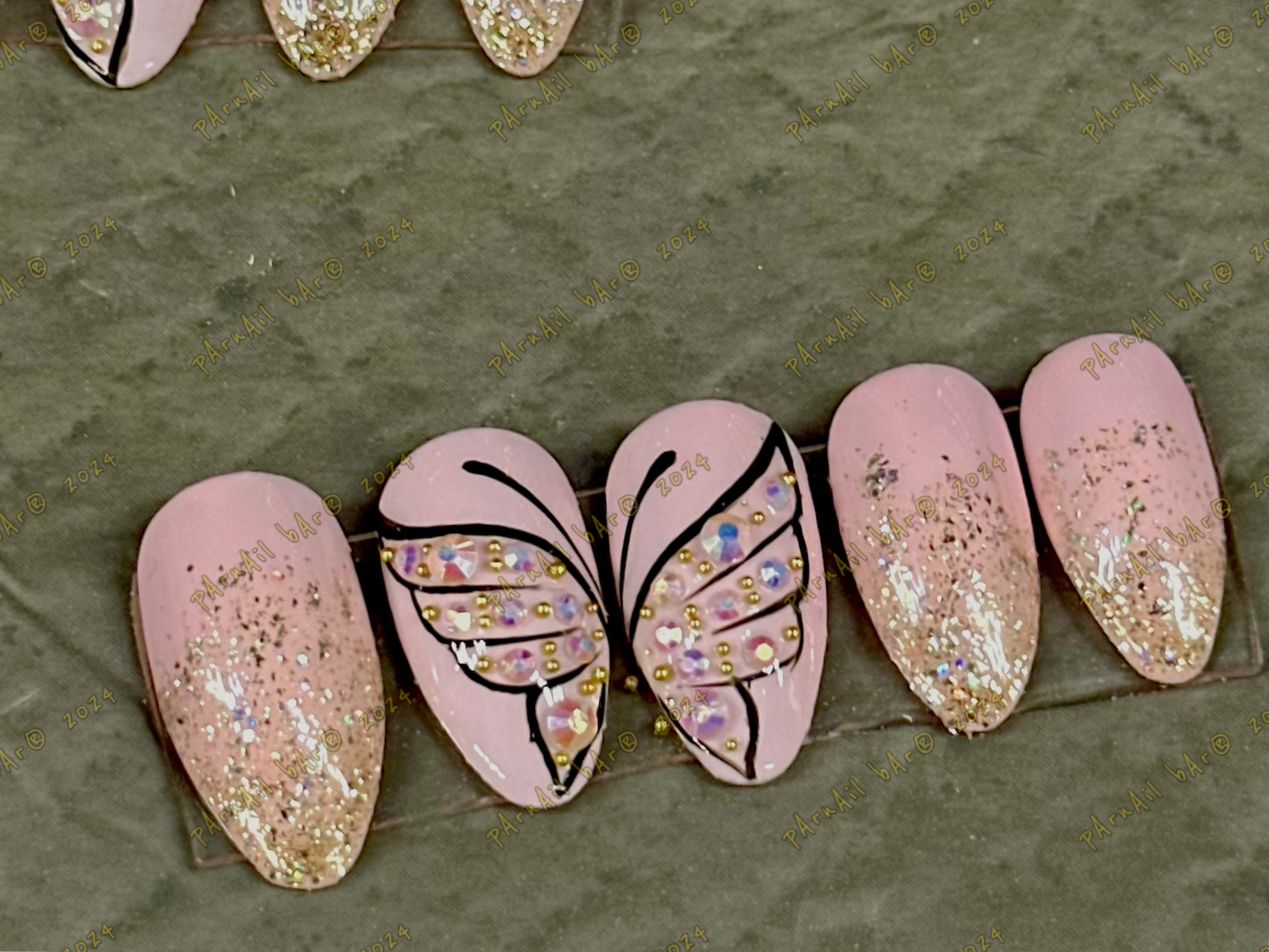 Pink butterfly nail art design with gold glitter