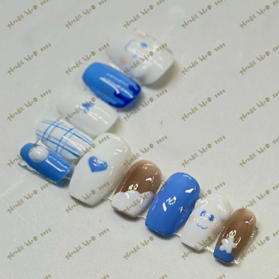 CinnamonAil press-on nails with blue, white, and brown designs