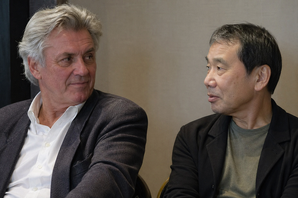 The image shows authors John Irving and Harmui Murakmi in conversation