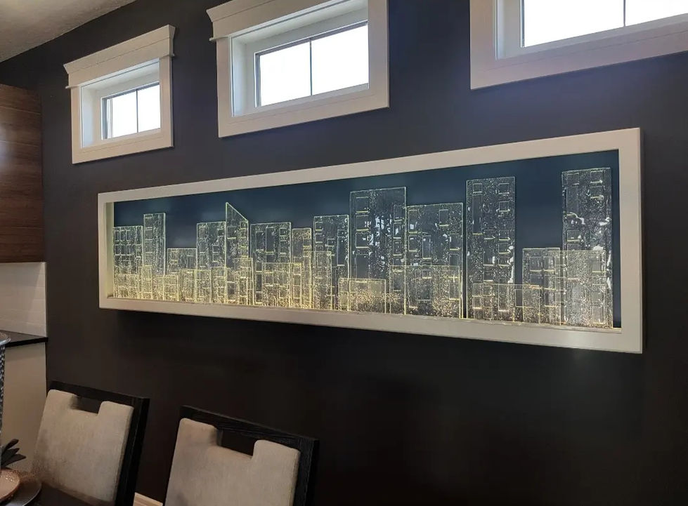 Glass City is a 3D glass art installation showcasing 10mm kilnformed glass pieces arranged within an LED light channel, creating an illuminated cityscape.