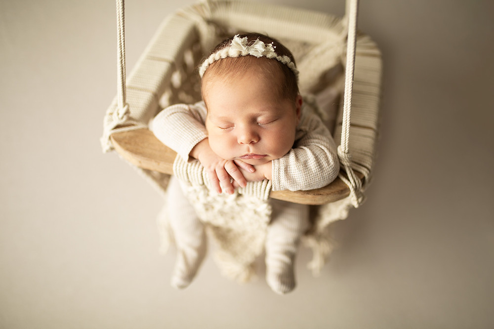 newborn baby girl in cream macrame swing at newborn photography session