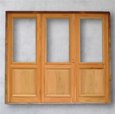 Portón de tres hojas, Modelo P. 803. Diseño clásico de madera con tablero inferior y marco superior para vidrio. Ideal para sistema de apertura plegadizo o batiente.