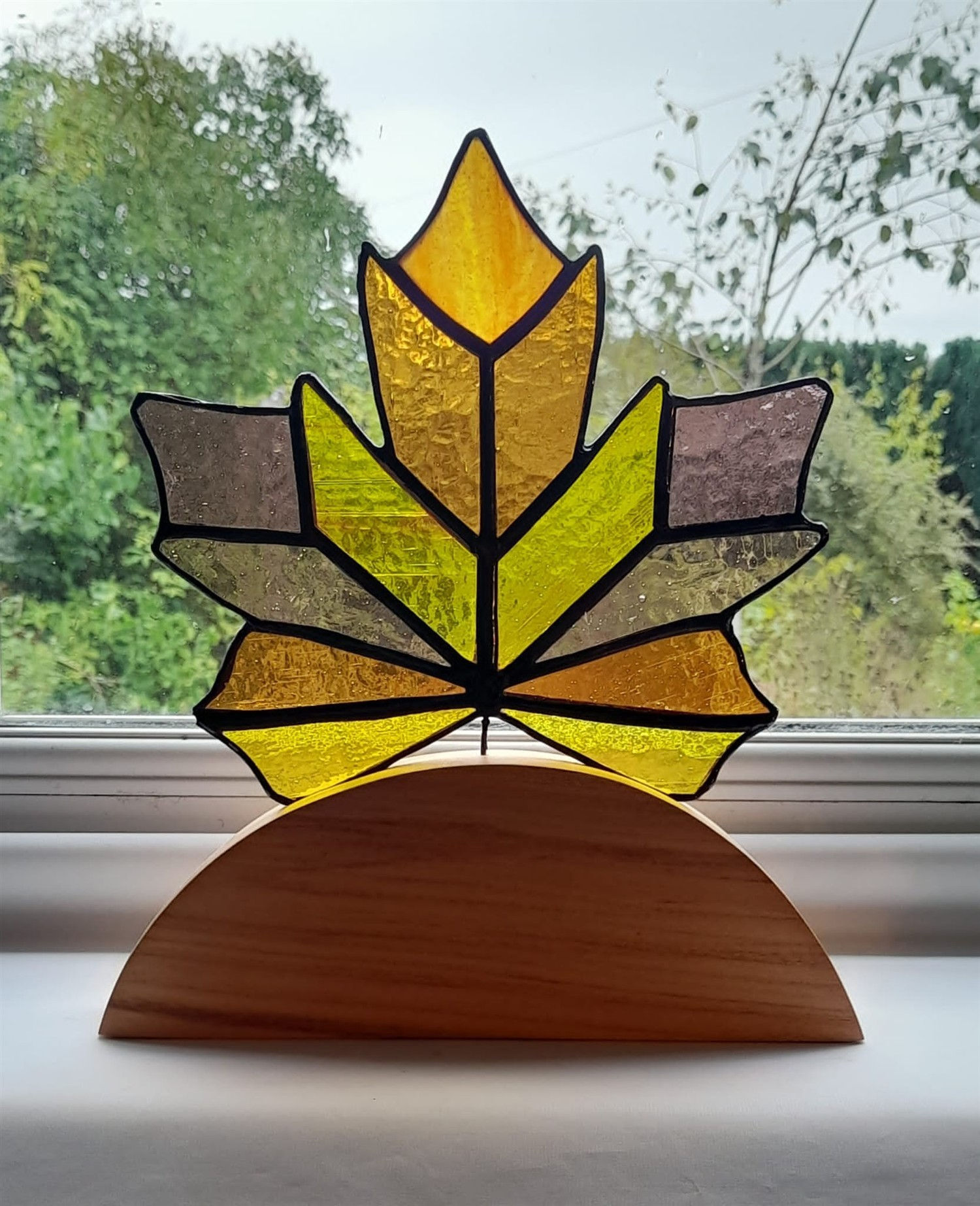 Stained Glass Maple Leaf on wooden log with natural background