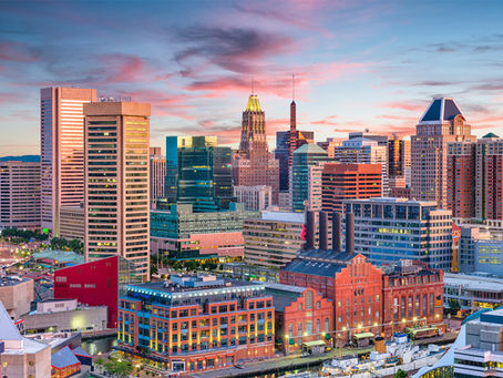 Baltimore skyline at sunset with Inner Harbor waterfront and downtown buildings near the Baltimore Convention Center