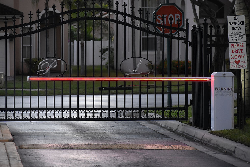 LED barrier arm in front of a heavy gate at entrance to a home community