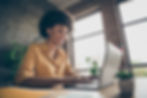 Photo of cheerful positive business lady smiling toothily looking into screen of notebook
