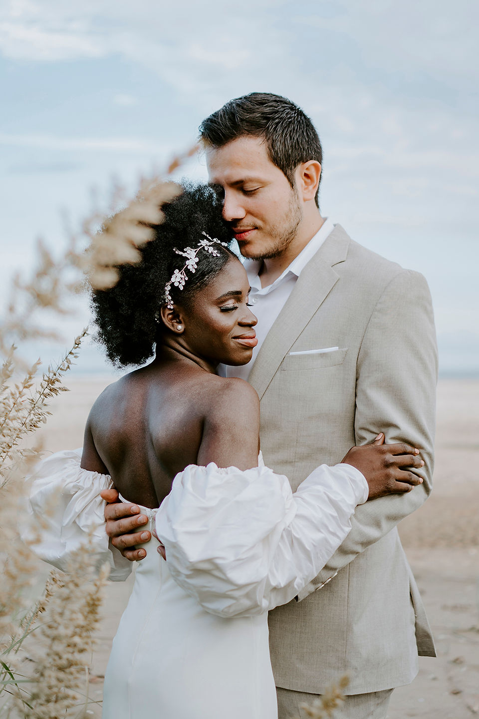 Romantic wedding interracial couple embracing on a floating dock surrounded by a moody and scenic natural landscape. Black Queen Bride
