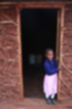 Young girl stands in doorway smiling