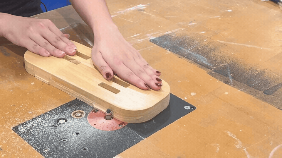 Using a router to chamfer the edges of wooden components, adding a professional finish to the lamp parts.