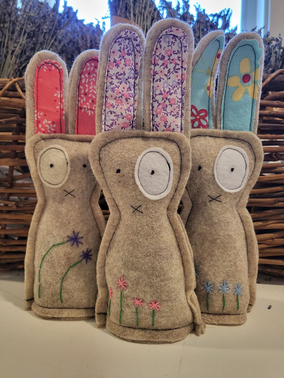 Thumbnail: Three beige colored "ugly" bunnies with pastel, fabric accents look to camera