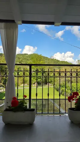 Camera di bed & breakfast, floreale, focus su giardino. / Bed and breakfast room, floral theme, with a focus on the garden.