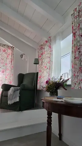 Camera di bed & breakfast, floreale, focus su letto, poltrona e spazio luminoso. / Bed and breakfast room, floral theme, focusing on the bed, armchair and bright space.