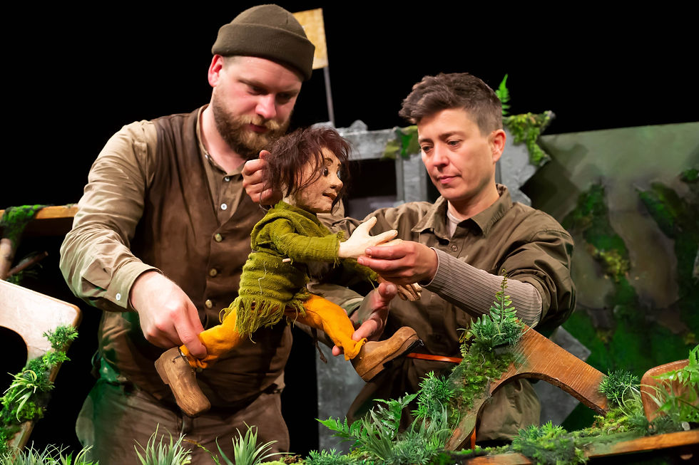 Zwei Puppenspieler mit einer hangeschnitzen Puppe