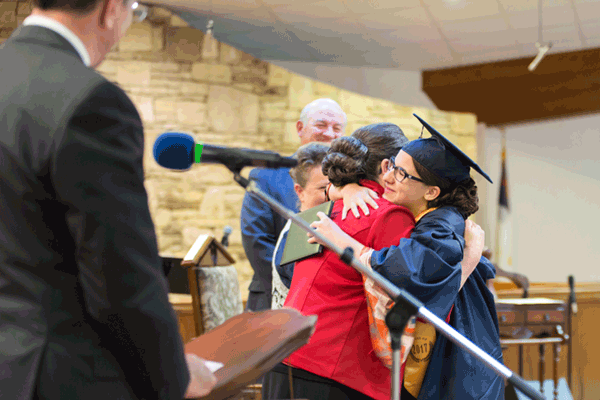 ( Courtesy of Pat Smith, CTM Photography ): Cynthia Young, Apostolic Academy high school teacher greets her daughter Marjorie after receiving her diploma during commencement exercises for Apostolic Academy.