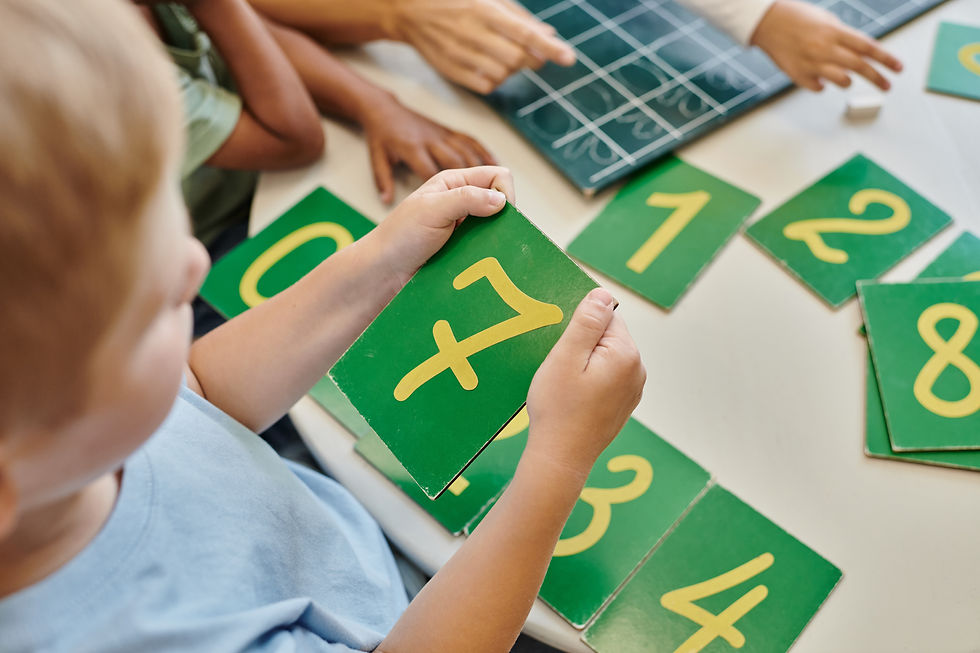 top view of boy holding number seven card, learning how to count in Montessori school, stu