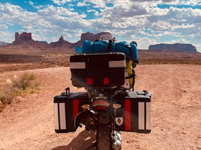 motorcycle, packed for a trip, driving across the desert