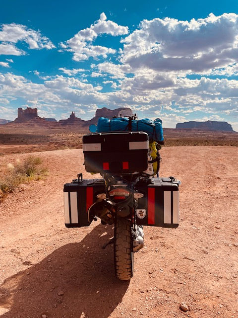 motorcycle, packed for a trip, driving across the desert
